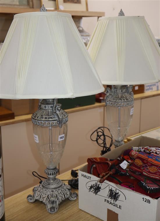 A pair of silvered metal and cut glass table lamps, shades over